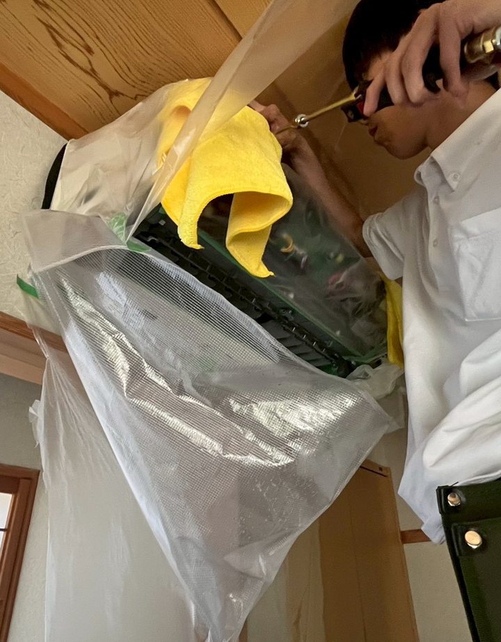 養生をしたうえでエアコンを分解し、内部を洗浄しているところ